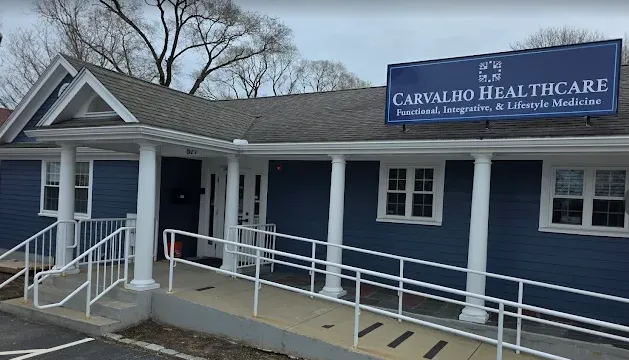 Fachada da cl&iacute;nica Carvalho Healthcare em Cape Cod, Massachusetts, com rampa de acessibilidade e ambiente acolhedor.